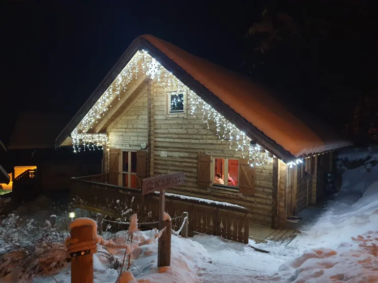 Le chalet illuminé sous la neige