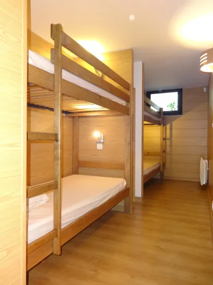 Grande chambre dortoir avec 4 lits superposés.