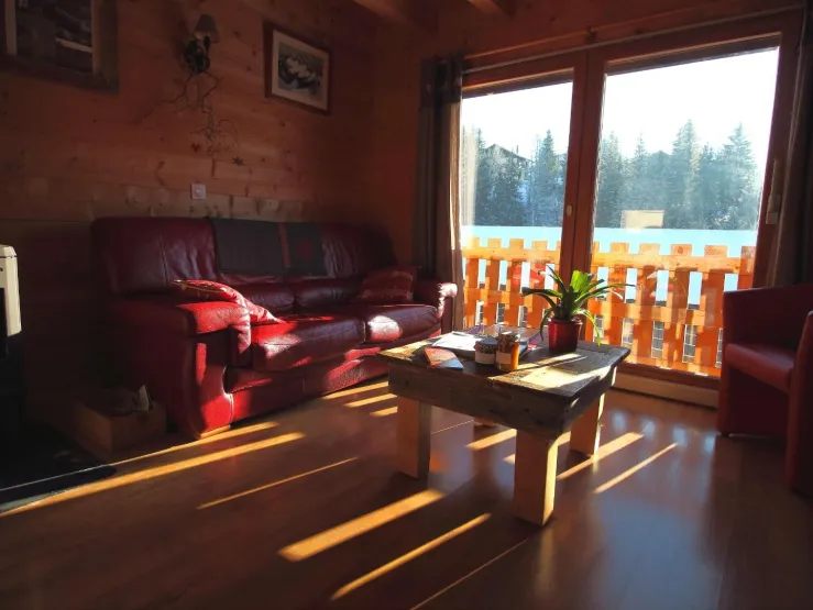 Le salon avec la grande baie vitrée exposée plein sud pour profiter largement du soleil